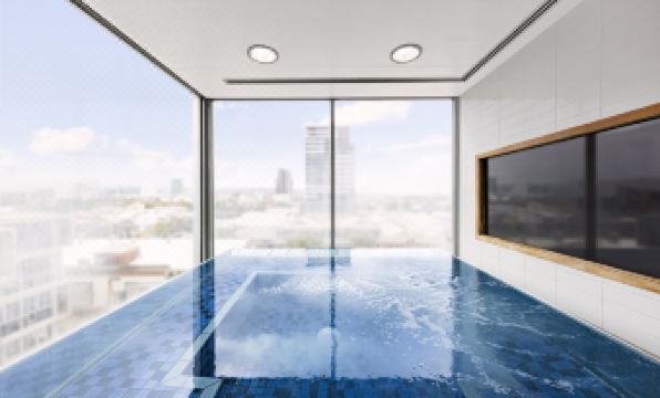 a large indoor swimming pool with blue water , surrounded by white walls and a city view from the top at IStay Precinct Adelaide