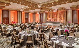 a large , well - lit banquet hall with multiple tables set for a formal event , including round tables and chairs at The Westin Chicago North Shore