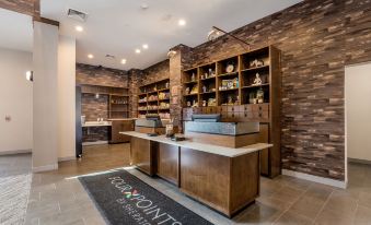 "a modern hotel lobby with a wooden reception desk , bookshelves , and a black carpet featuring the logo of "" igdt points ""." at Four Points by Sheraton Elkhart