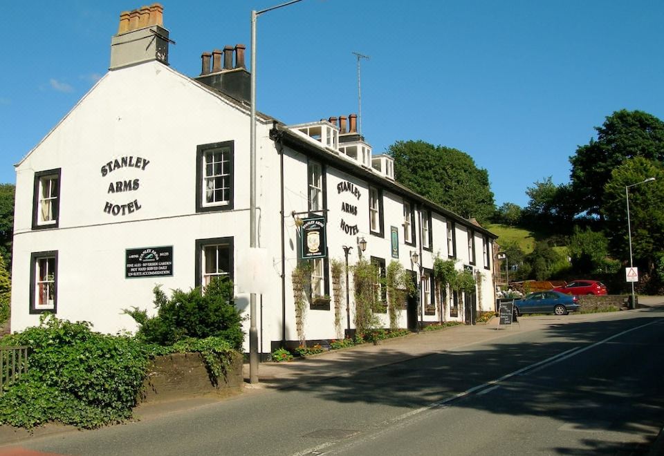 "a white building with a sign that reads "" stanley arms "" is situated on a street corner" at Stanley Arms Hotel