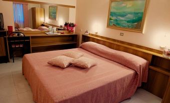 a hotel room with a large bed , pink sheets , and a painting on the wall at Hotel Europa