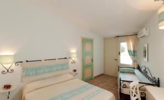 a well - decorated hotel room with a large bed , a desk , and a window overlooking the ocean at La Plage Resort