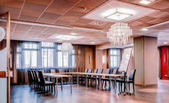 a large conference room with multiple tables and chairs arranged for a meeting or event at Hotel Engel