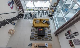 An aerial view reveals the spacious living room and kitchen with white walls at JK Maritime Luxury Suite