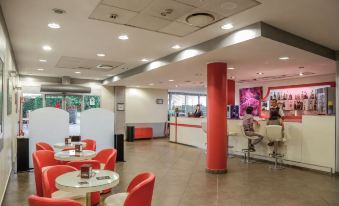 a modern cafeteria with red and white decor , a dining area , and several people enjoying their meals at Hotel Motel Prestige