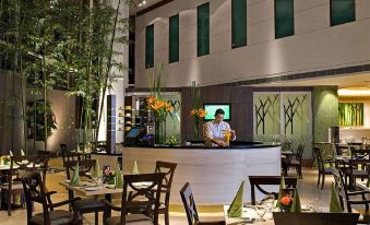 The restaurant has an open concept with tables, chairs, and a counter at Eastin Hotel Kuala Lumpur
