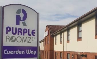 "a purple room 2 7 and a sign that says "" purple room 2 7 "" in front of a white building" at Purple Roomz Preston South