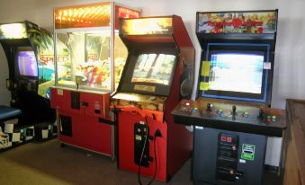 a room filled with various arcade games , including a nintendo wii game and a nintendo wii racing game at Best Western Park Oasis Inn