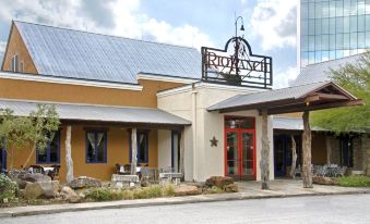 "a building with a sign that says "" ridy "" has two red doors and an outdoor patio area" at Hilton Houston Westchase