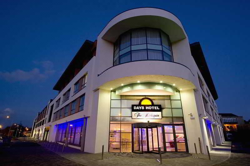 a hotel entrance with a large sign above the door , welcoming guests to the days hotel at The Ellison