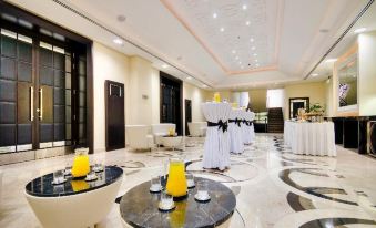 a well - decorated hotel lobby with white and black tables , chairs , and a large mirror in the background at AX The Palace