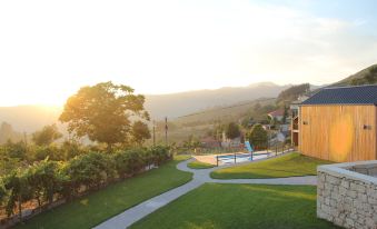 a beautiful view of a mountainous landscape , with the sun setting behind trees and buildings , and a winding path leading to a building at Casa de Lobos