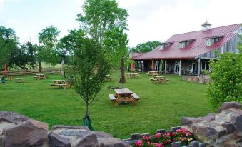 a large , well - maintained lawn with several picnic tables and benches surrounded by trees and grass at Courtyard Manassas Battlefield Park