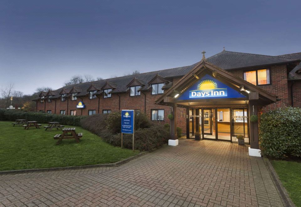 an exterior view of a days inn hotel , with a large sign above the entrance at Days Inn by Wyndham Sevenoaks Clacket Lane