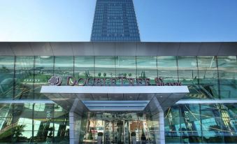 the exterior of the jonolutssen head office , with its glass facade and the name visible on its signboard at DoubleTree by Hilton Istanbul-Avcilar