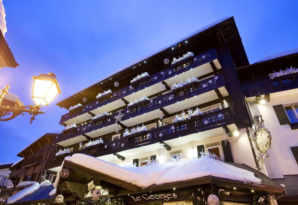 a large , modern building with a traditional chinese architectural style and a large stone structure on the roof at Hotel Mont Blanc Megève