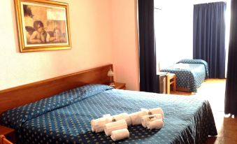 a hotel room with two beds , one on the left and one on the right side of the room at Hotel Rio Sanremo
