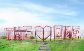 "a grassy field with a large metal sign that reads "" heaven "" prominently displayed on it" at Hotel the One