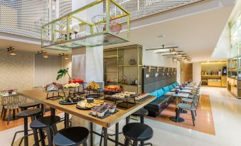 a dining area with a long wooden table filled with various food items and utensils at Room Mate Giulia