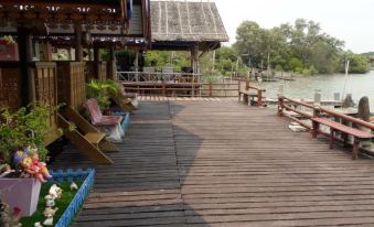 a wooden deck overlooking a body of water , with several chairs placed around the area at Sampaongern Home Stay