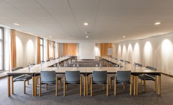 a large conference room with multiple tables and chairs , set up for a meeting or event at Grandhotel Giessbach