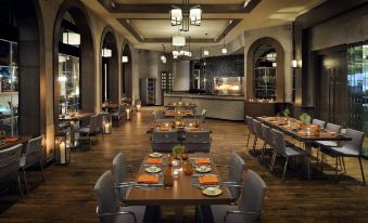 a large dining room with multiple tables and chairs arranged for a group of people to enjoy a meal together at Amman Marriott Hotel