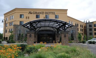 the grand hotel has a stone entrance with an arched entrance and a large sign above it at Grand Hotel at Bridgeport