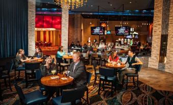 a group of people are sitting at tables in a restaurant with tables and chairs at Akwesasne Mohawk Casino Resort and Players Inn Hotel -Formerly Comfort Inn and Suites Hogansburg NY