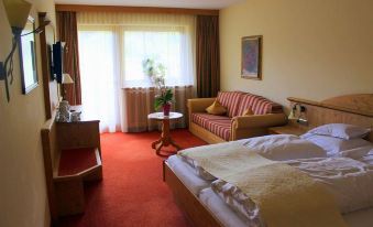 a hotel room with a bed , couch , and tv . also a dining table in the room at Hotel Königsblick by Keyone