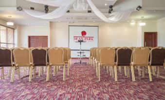 a conference room with chairs arranged in rows and a projector screen mounted on the wall at Dean Park Hotel