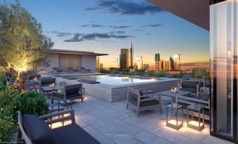 a rooftop patio with a hot tub , lounge chairs , and a view of a city skyline at sunset at Hotel Viu Milan, a Member of Design Hotels