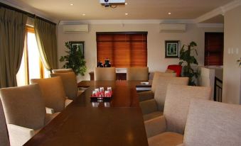 a conference room with a long wooden table , chairs , and a projector mounted on the wall at Hole in One