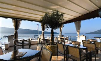 an outdoor dining area at a restaurant , with tables and chairs set up for guests to enjoy their meal at Hotel Perla