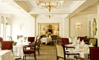 a well - decorated dining room with tables and chairs arranged for a group of people to enjoy a meal at The Keadeen Hotel