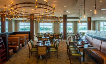 a large dining room with numerous tables and chairs , some of which are occupied by people at Owensboro Riverfront