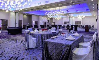 a large banquet hall with multiple dining tables set up for a formal event , possibly a wedding reception at Courtyard Lake Jackson