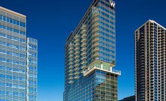 a modern , multi - story building with large windows and a unique tower design , standing against a clear blue sky at W Atlanta – Downtown