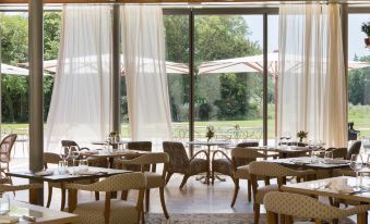 an elegant dining room with wooden tables and chairs arranged for a group of people to enjoy a meal at Chateau de Fonscolombe