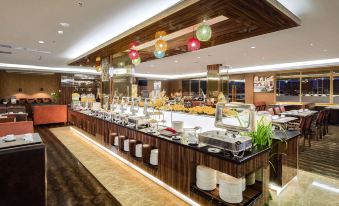 a large dining room with a long buffet table filled with various food items and utensils at Best Western Plus Makassar Beach