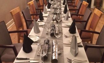 a long dining table set for a formal dinner , with multiple wine glasses and utensils arranged neatly on the table at The Prince Consort