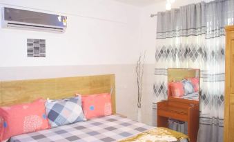 a cozy bedroom with a wooden bed , a dresser , and a mirror on the wall at Luxury Apartment