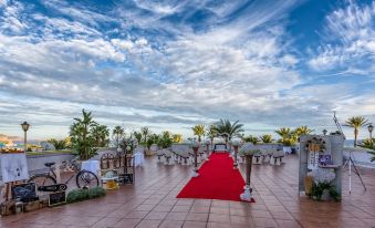 a red carpet is set up on a rooftop with chairs and tables around it at Playadulce