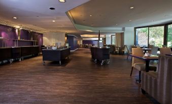 a large , open room with a dining area and several tables and chairs , possibly in a hotel or restaurant setting at Doubletree by Hilton Montreal