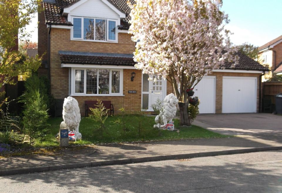 a brick house with a large tree in the front yard , creating a picturesque scene at The Den