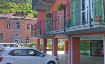 a white car parked in front of a multi - story building , with the surrounding area colored in pink and green at Franco