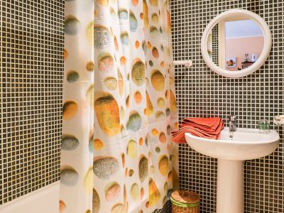 a bathroom with a shower curtain featuring dots , a sink , and a mirror above the sink at Lanzarote