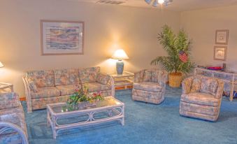 a living room with multiple couches and chairs , along with a ceiling fan and potted plants at Sunrise