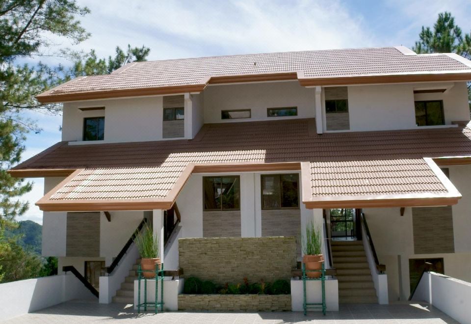 a large house with a brown roof and white walls has two potted plants on the side at Casa Mia