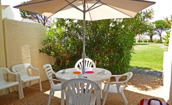 a white table with chairs under an umbrella is set up in an outdoor area at Antigua