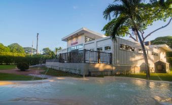 a modern house with a swimming pool in the backyard , surrounded by lush greenery and palm trees at Fiesta Resort All Inclusive Central Pacific - Costa Rica